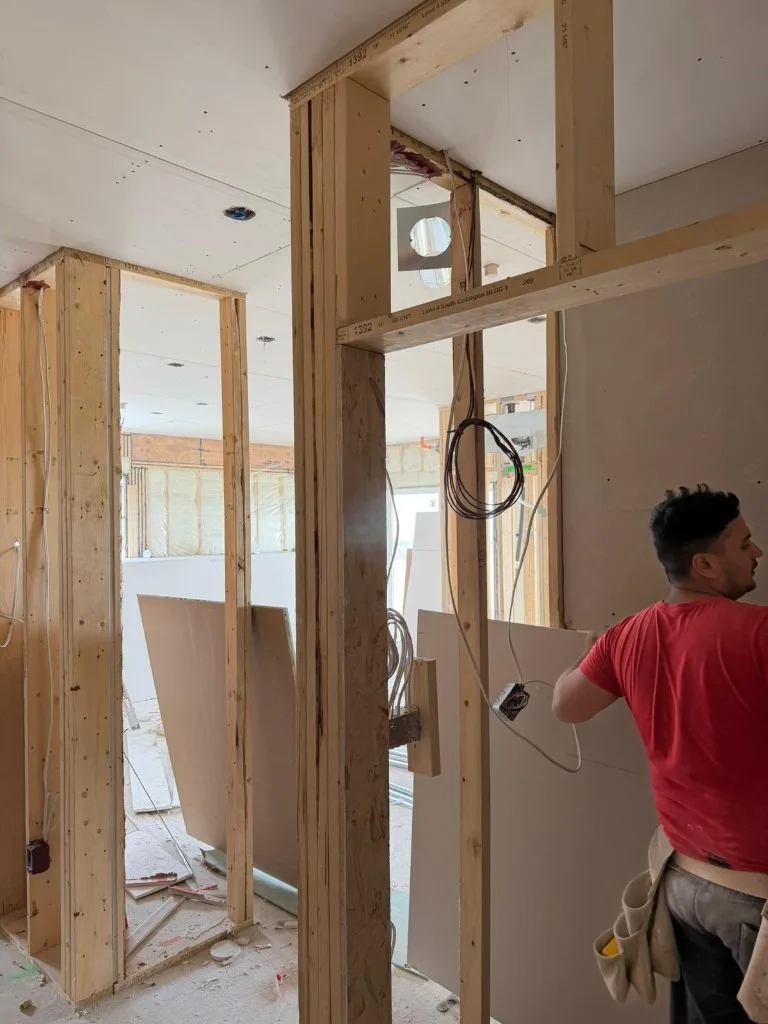 Large window wall with mudded drywall and construction site view